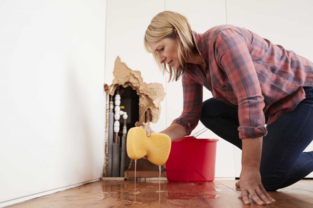 woman cleaning up water damage in her home